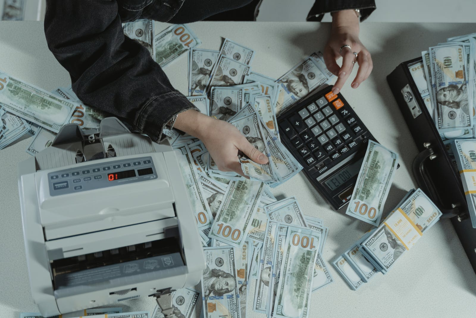 Una persona que cuenta una pila de dinero, lo que representa el lavado de dinero
