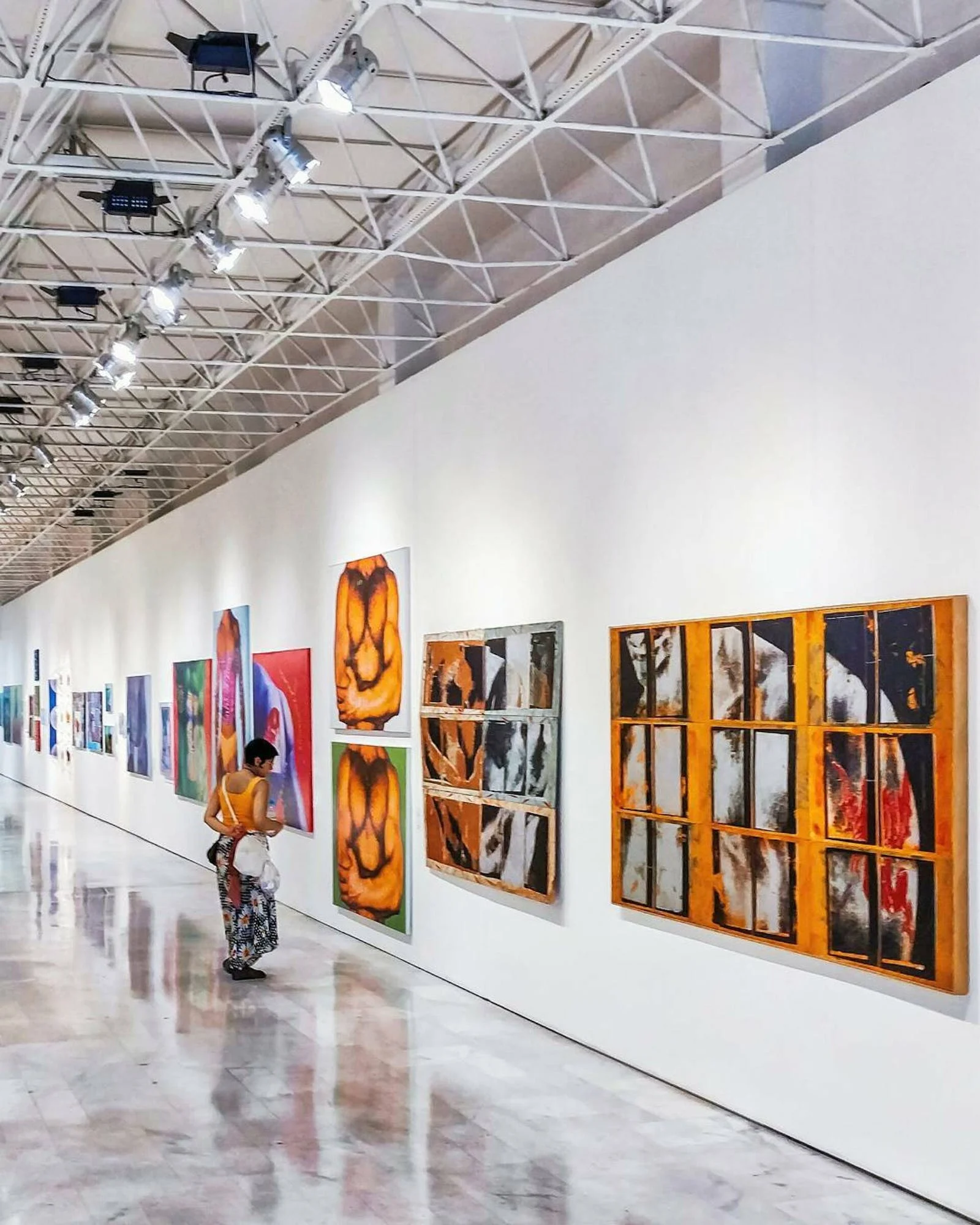 Una persona mirando un cuadro en una galería de arte, representando el atractivo del mercado del arte para los lavadores de dinero