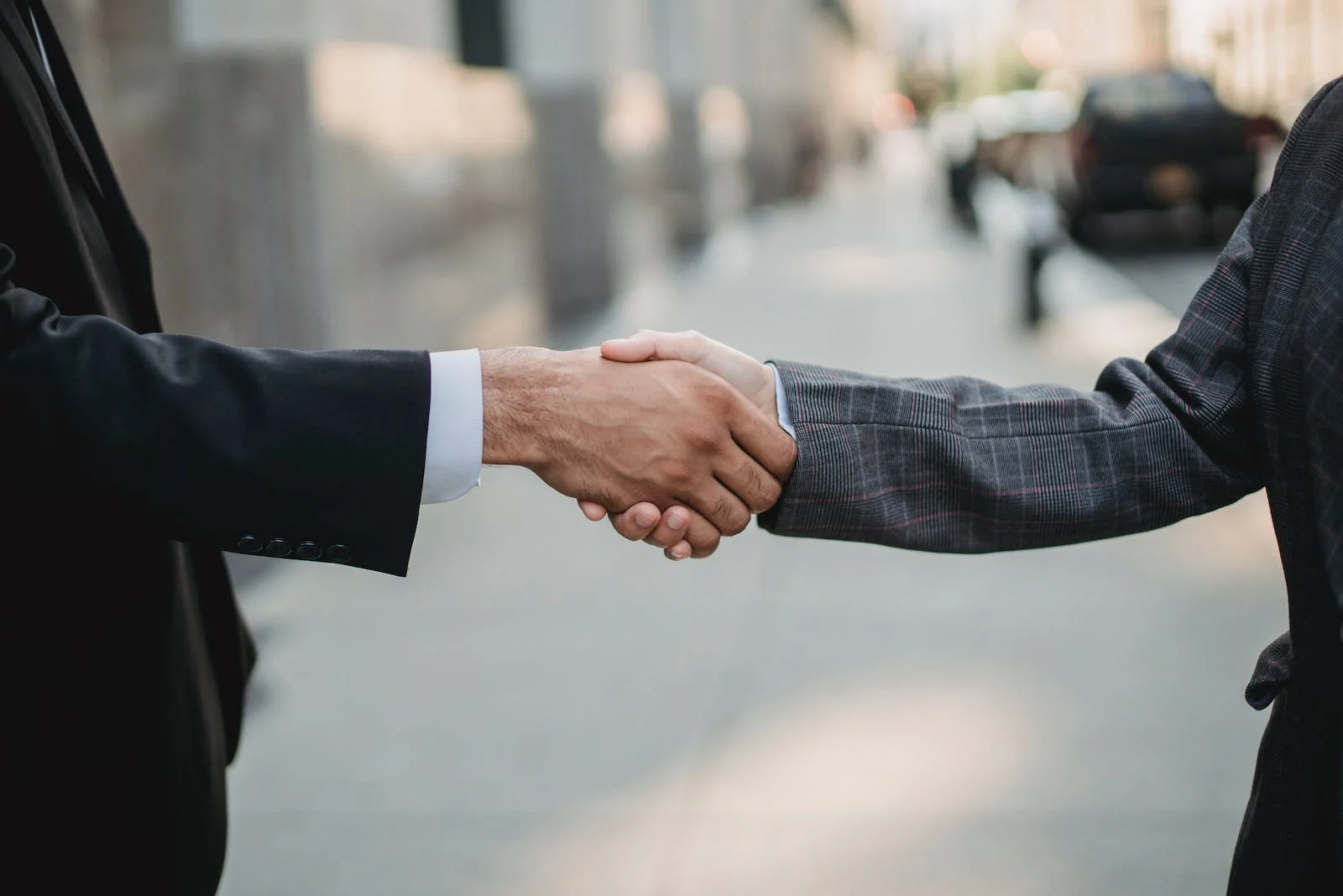 Una persona de traje estrechando la mano de otra persona de traje, simboliza la implementación de medidas anticorrupción
