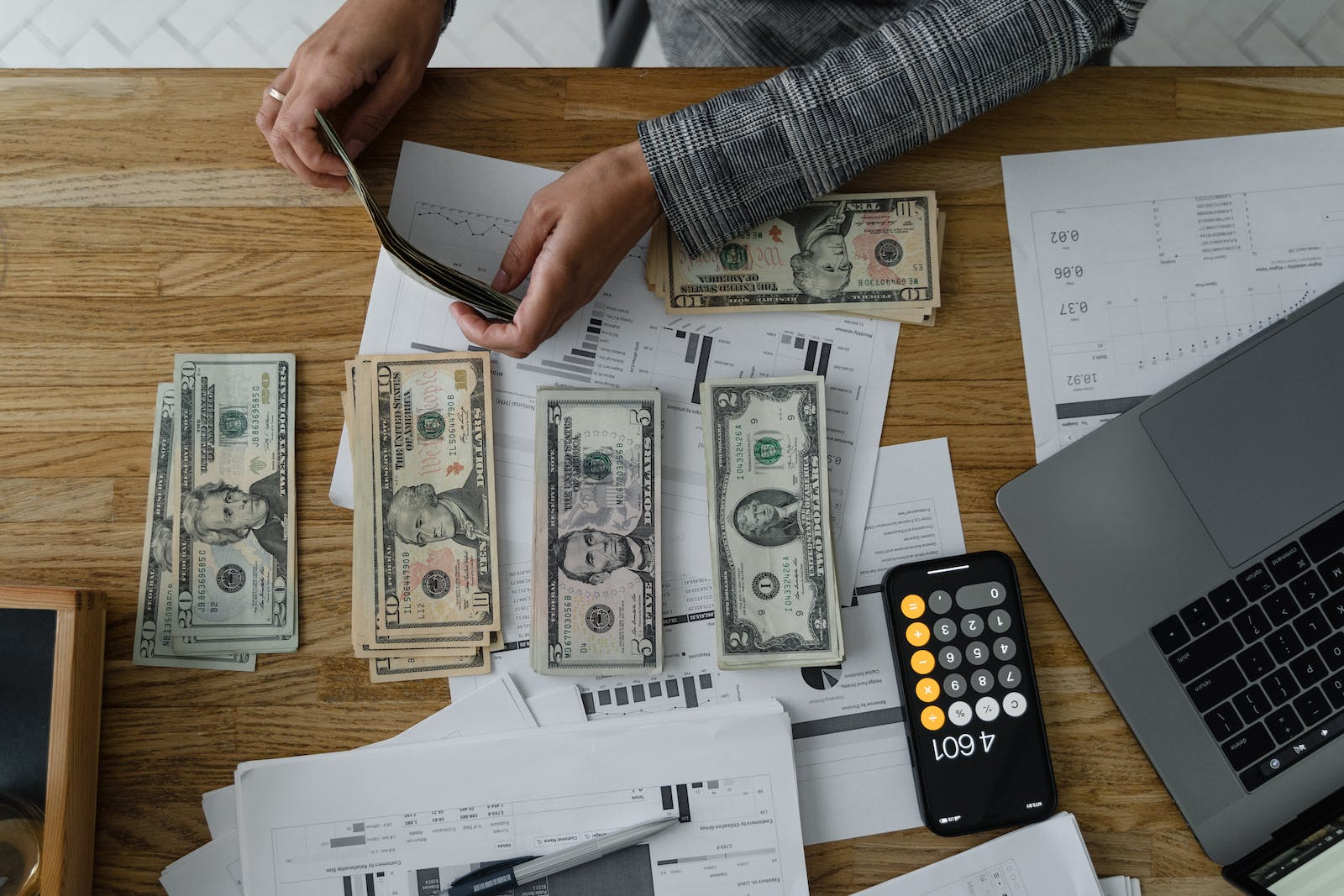 Una persona contando una pila de dinero, que representa ejemplos de lavado de dinero de la vida real