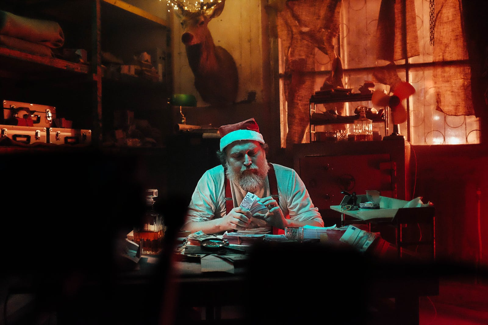 A man counting money in a dark room, representing organized crime and money laundering